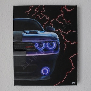 以下が含まれることがあります： 黒と紫のダッジチャレンジャーSRTの絵。車のヘッドライトは明るい青色の光で輝いています。赤い稲妻が黒いキャンバスの背景に描かれています。「SRT」の文字が車の前面に見えます。