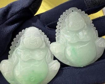 Op de afbeelding: Twee jadeïeten Boeddha-hangers, elk met een lachend gezicht en een grote buik. De hangers zijn lichtgroen en wit, met ingewikkelde details rond de randen. De hangers zijn gelabeld A en B.
