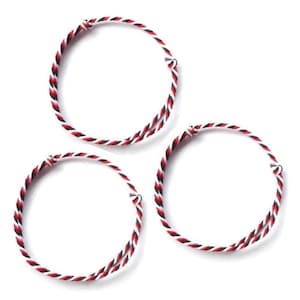 May include: Three circular bracelets made of twisted red, black, and white cord. The bracelets are knotted at the ends. The background is plain white.