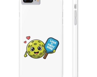 Könnte beinhalten: Weißes Smartphone-Case mit einem Cartoon-Pickleball mit lächelndem Gesicht, das einen blauen Schläger mit dem Text "LOVE AT FIRST DINK" hält. Zwei rote Herzen schweben darüber. Für ein Mobiltelefon.