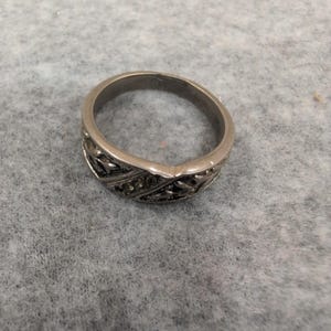 Anillo vintage de plata con relieve floral y detalles incrustados. imagen 2