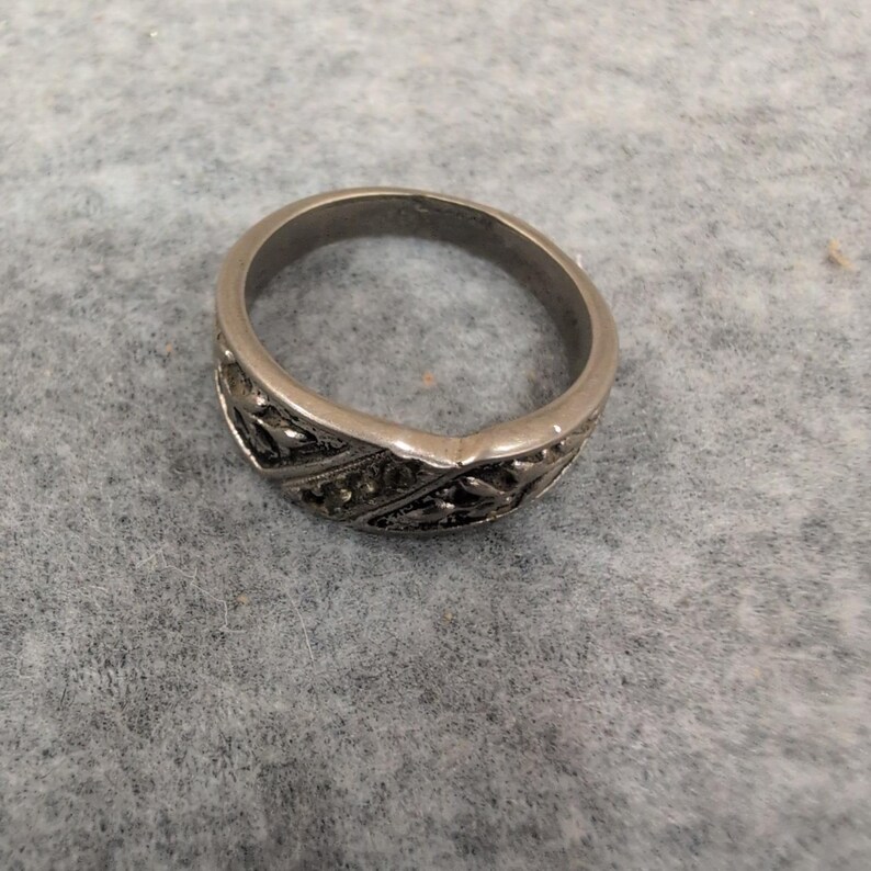 Anillo vintage de plata con relieve floral y detalles incrustados. imagen 2
