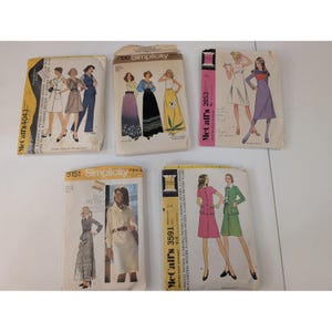 Puede incluir: Cinco patrones de costura vintage. Los patrones presentan ilustraciones de diseños de ropa de mujer de la década de 1970. Los patrones son de McCall's y Simplicity, con texto que incluye números de patrón y precios.