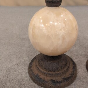 Juego de 2 remates decorativos de hierro fundido y piedra con diseño de flor de lis, color marrón crema. imagen 2