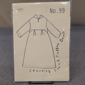 以下が含まれることがあります： ショールカラーのドレスの縫製パターンパッケージ、No. 99と表示されています。イラストはドレスのデザインの線画です。パッケージは透明なビニールスリーブに入っています。