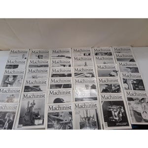 Könnte beinhalten: Eine Sammlung von "Machinist"-Magazinen mit Schwarz-Weiß-Bildern von Maschinen und Werkzeugen. Die Zeitschriften sind auf einer weißen Oberfläche gestapelt, wobei der Titel deutlich sichtbar ist.