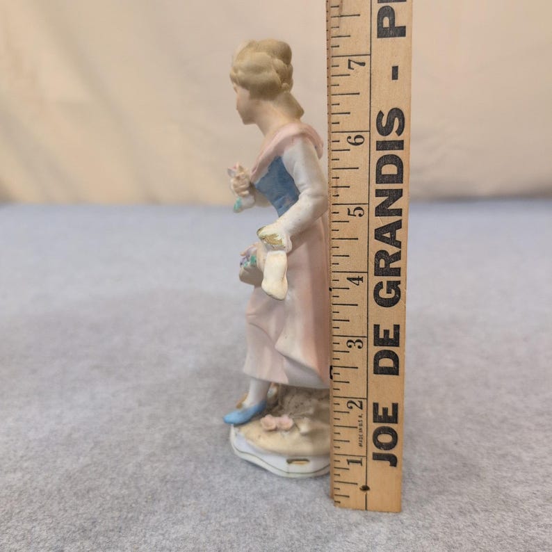 Estatueta vintage de porcelana biscuit representando uma mulher com uma cesta de flores em tons de rosa, azul e branco. imagem 4