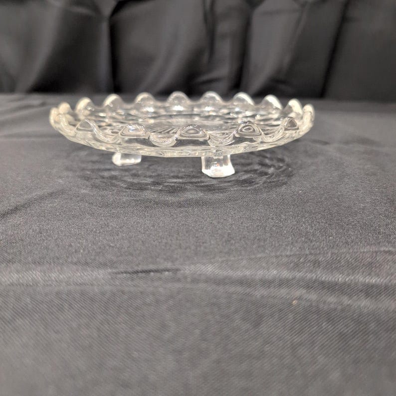 Vintage onderzetter van helder geperst glas met honingraatmotief, geschulpte rand en zonnestralenmotief in het midden. afbeelding 2
