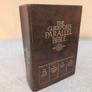 May include: A brown hardcover book titled "The Guideposts Parallel Bible." The book compares four popular Bible translations: King James Version, Modern Language Bible, Living Bible, and Revised Standard Version. The cover has silver lettering.