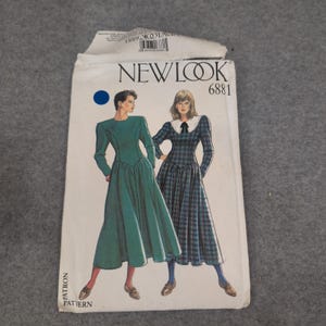 Może przedstawiać: Vintage wzór krawiecki New Look, z ilustracjami dwóch sukienek. Jedna sukienka jest turkusowa, druga w kratę z białym kołnierzem. Numer wzoru to 6881.