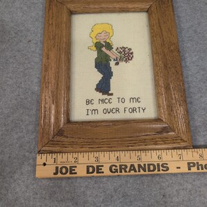 Cuadro decorativo de punto de cruz vintage con marco de madera "Sé amable conmigo, tengo más de cuarenta años". imagen 3