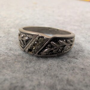 Anillo vintage de plata con relieve floral y detalles incrustados. imagen 1