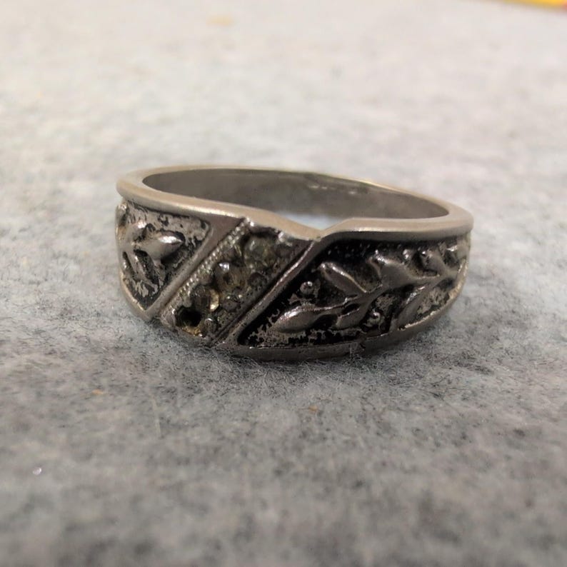 Anillo vintage de plata con relieve floral y detalles incrustados. imagen 1