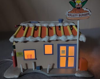 Escultura iluminada de Krusty Burger en la Aldea Navideña de Hawthorne Village de Los Simpson