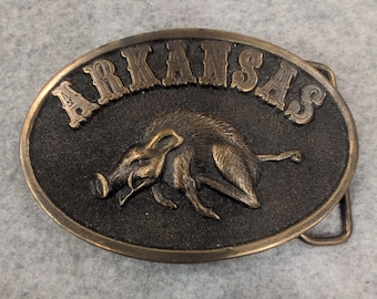 Hebilla de cinturón vintage de 1976 de AJ Dezy Denver Arkansas Razorback en tono latón.