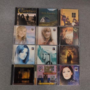 Könnte beinhalten: Eine Sammlung von zwölf CDs in Jewelcases. Die Albumcover zeigen Bilder von Musikern, Landschaften und Porträts. Zu den Titeln gehören "Clannad", "Irish Hymns", "Chloe", "Lisa", "Moav" und "Irish Pub Songs".