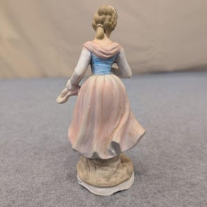 Estatueta vintage de porcelana biscuit representando uma mulher com uma cesta de flores em tons de rosa, azul e branco. imagem 3