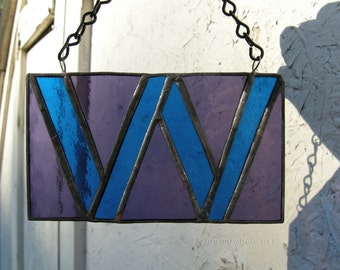 Stained glass W with Wellesley College class colors