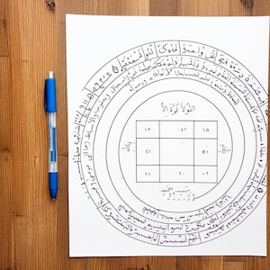 Puede incluir: Un papel blanco con intrincados diseños circulares negros y texto, incluyendo una cuadrícula cuadrada central con números. Un bolígrafo azul descansa en el lado izquierdo. El papel está sobre una superficie de madera.