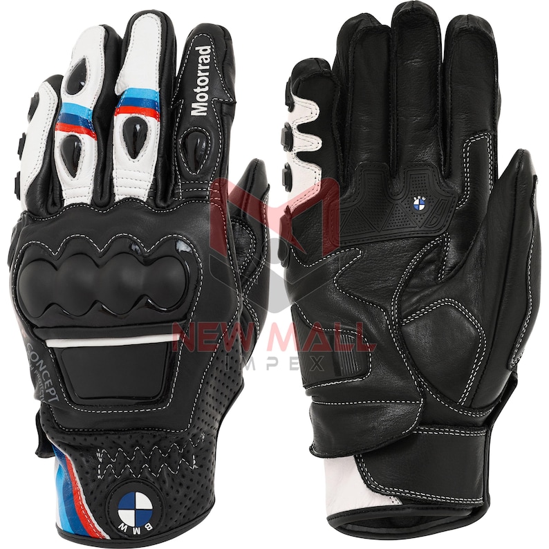 May include: Black and white motorcycle gloves with the word "Motorrad" printed on the side. The gloves have a knuckle protector and the BMW logo. The gloves have white stitching and accents of blue and red.