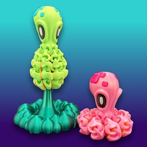 May include: Two articulated octopus figures with large eyes and patterned heads. The taller figure is lime green with a metallic teal base, while the smaller figure is bright pink with darker pink accents. Both feature flexible, segmented tentacles.