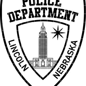 May include: A black and white police badge design. The words "POLICE DEPARTMENT" are at the top. The badge includes the text "LINCOLN NEBRASKA", a building illustration, and a star.