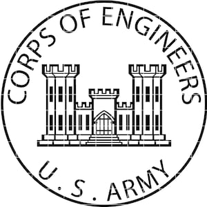Op de afbeelding: Zwart-wit cirkelvormig embleem met de tekst "CORPS OF ENGINEERS" en "U.S. ARMY". Het centrale ontwerp toont een gestileerd kasteel met twee torens en een centraal gebouw.