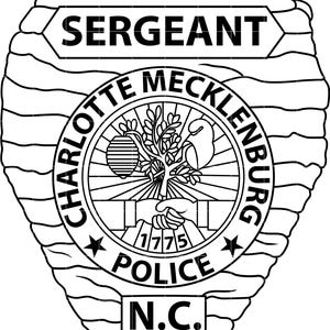 Könnte beinhalten: Schwarz-weiß Polizei-Sergeant-Abzeichen. Das Abzeichen zeigt die Wörter "SERGEANT", "CHARLOTTE MECKLENBURG POLICE N.C." und das Jahr "1775". Das Abzeichen hat eine Schildform mit strukturiertem Rand und einem zentralen Emblem.