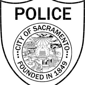 Può includere: Distintivo della polizia di Sacramento in bianco e nero. La parola "POLICE" è in alto. Il centro presenta un emblema circolare con le parole "CITY OF SACRAMENTO" e "FOUNDED IN 1849" che circondano una scena cittadina dettagliata.
