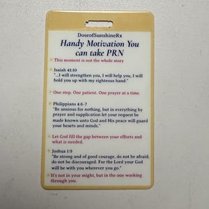 May include: A cream-coloured rectangular card with rounded corners. The card features the text "DoseofSunshineRx" and "Handy Motivation You can take PRN." Several inspirational quotes are printed on the card, including verses from Isaiah, Philippians, and Joshua.