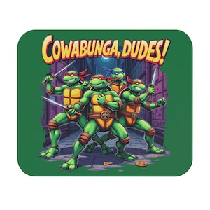 Puede incluir: Una alfombrilla de ratón verde con las Tortugas Ninja. Las tortugas están representadas en una escena callejera, sosteniendo armas, con la frase "Cowabunga, Dudes!" en texto amarillo y rojo.