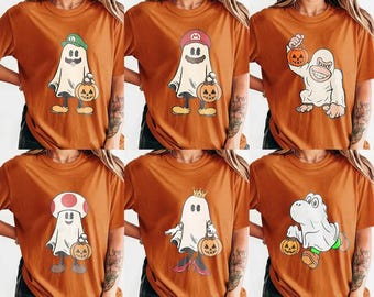 Könnte beinhalten: Sechs gebrannte orangefarbene T-Shirts mit Grafikdrucken von Charakteren, die als Geister für Halloween verkleidet sind. Die Motive zeigen Figuren mit Hüten, Kronen oder Masken, die jeweils einen Kürbis-Eimer zum Süßes-oder-Saures-Sammeln halten.