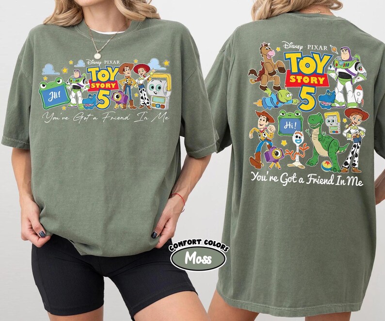 Może przedstawiać: Zielona koszulka w kolorze mchu z grafiką Toy Story i napisem "Toy Story 50". Z przodu koszulki znajduje się napis "You've Got a Friend In Me" oraz żaba z napisem "Hi!". Z tyłu koszulki r&oacute;wnież znajduje się napis "You're Got a Friend In Me".
