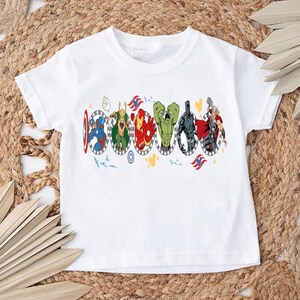 Puede incluir: Camiseta blanca con un gr&aacute;fico colorido de superh&eacute;roes en marcos ovalados. El dise&ntilde;o incluye al Capit&aacute;n Am&eacute;rica, Thor, Iron Man y otros. La camiseta est&aacute; hecha de un material suave y es adecuada para ni&ntilde;os.