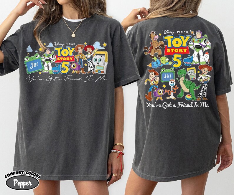 Może przedstawiać: Ciemnoszara koszulka z kolorową grafiką postaci z Toy Story oraz napisem "Toy Story 5" i "You've Got a Friend In Me". Koszulka ma luźny kr&oacute;j i kr&oacute;tkie rękawy.
