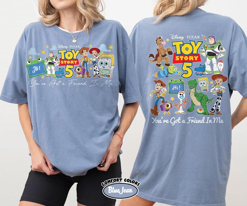 Może przedstawiać: Jasnoniebieska koszulka z motywem z filmu Disneya i Pixara Toy Story. Prz&oacute;d koszulki przedstawia napis "Toy Story 5" i postacie. Tył koszulki r&oacute;wnież zawiera ten sam wz&oacute;r i frazę "You're Got a Friend In Me."