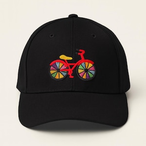 May include: Black baseball cap with a colorful embroidered bicycle design. The bicycle features a red frame, yellow seat, and wheels with rainbow-colored spokes. A stylish accessory for cycling enthusiasts.