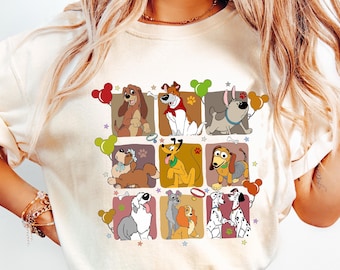 May include: Cream-colored sweatshirt featuring a grid of cartoon dog illustrations. Each dog is in a square with a different color background. Some dogs hold balloons. Stars and paw prints are scattered around the squares.