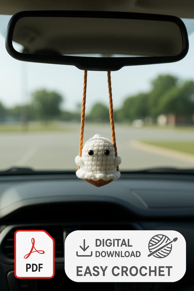 Peut inclure: Un charm de voiture en crochet blanc en forme de fant&ocirc;me, suspendu au r&eacute;troviseur d'une voiture par des cordons orange. Le fant&ocirc;me a des yeux noirs et un bord fronc&eacute;. L'image comprend une ic&ocirc;ne PDF et les mots "T&Eacute;L&Eacute;CHARGEMENT NUM&Eacute;RIQUE FACILE CROCHET".