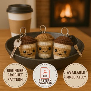May include: Three crocheted coffee cup keychains with smiling faces, each attached to a key. The keychains are brown, beige, and white. They are displayed in a dark bowl, with a paper coffee cup in the background. The words "BEGINNER CROCHET PATTERN", "PDF PATTERN DOWNLOAD", and "AVAILABLE IMMEDIATELY" are in the image.