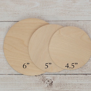 May include: Three unfinished wooden circles of varying sizes, labeled 6", 5", and 4.5". The circles are made of light-coloured wood and are arranged on a light-coloured wooden surface.