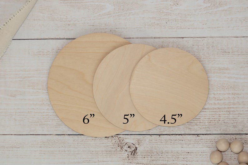 May include: Three unfinished wooden circles of varying sizes, labeled 6", 5", and 4.5". The circles are made of light-coloured wood and are arranged on a light-coloured wooden surface.