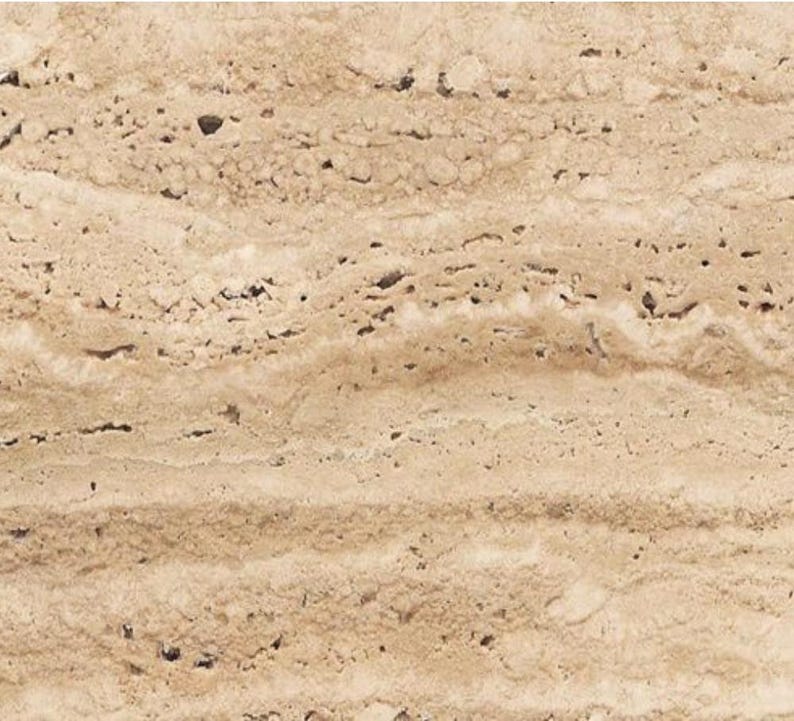 May include: Close-up of a beige travertine stone surface. The stone has a natural, porous texture with horizontal bands of varying shades of tan and brown. The surface has small holes and imperfections.