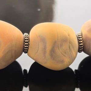Handgemaakte lampworkkralen: karamel-amberkleurige nuggets geëtst tot een zachte, matte afwerking