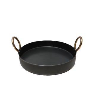 Könnte beinhalten: Ein runder Servierteller aus schwarzem Metall mit zwei messingfarbenen Griffen. Der Teller hat einen Durchmesser von etwa 35 cm und eignet sich zum Servieren von Speisen oder zum Präsentieren von Gegenständen. Die Griffe sind gebogen.