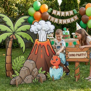 Peut inclure: Scène de fête d'anniversaire sur le thème des dinosaures avec des découpes en carton d'un volcan, d'un palmier et d'un bébé dinosaure sortant d'un œuf. Une pancarte indique "DINO PARTY !" Des ballons et un gâteau complètent la scène.