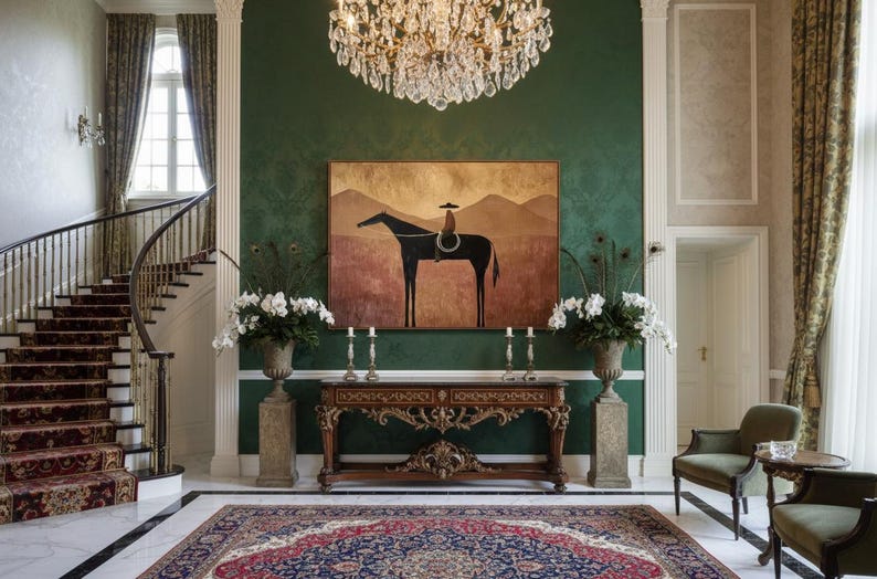 May include: Elegant entryway with a grand staircase, ornate rug, and a decorative console table. A painting of a horse and rider hangs above the table. The room features a crystal chandelier and green walls.