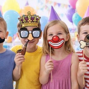 May include: Four children wearing party hats and holding photo booth props. Props include a black mustache, a crown with glasses and a pipe, a clown nose and mouth, and a dog nose with a bone that says "BIG DOG".