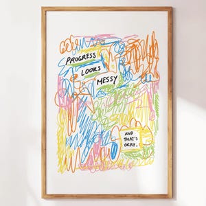 Könnte beinhalten: Ein gerahmter Kunstdruck mit weißem Hintergrund und bunten Kritzeleien in Orange, Gelb, Blau, Rosa und Grün. Der Text "PROGRESS LOOKS MESSY" ist zu sehen, sowie "AND THAT'S OKAY."