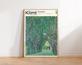 Puede incluir: Una impresión artística enmarcada de "Avenue to the Kammer" de Gustav Klimt, que presenta un camino bordeado de árboles verdes. La impresión incluye el nombre del artista y la ubicación, Viena, Austria. La obra de arte se exhibe sobre un suelo de madera contra una pared blanca.